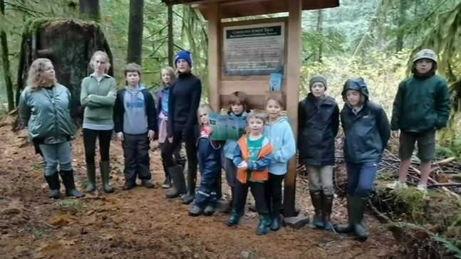 Surge Narrows students and teacher Susanne Hrybko stand at start of Read Island Nature Trail.